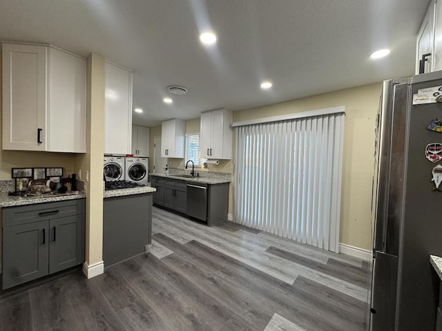 kitchen featuring appliances with stainless steel finishes, gray cabinetry, white cabinetry, and washer and dryer