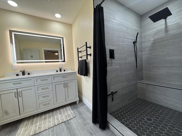 bathroom with ceiling fan, a shower with shower curtain, wood-type flooring, and vanity