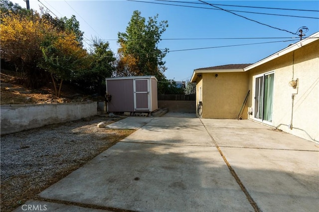 view of yard featuring a patio and a storage shed