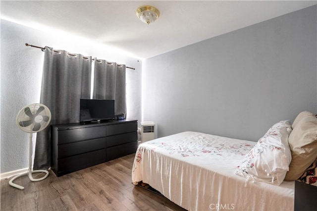 bedroom featuring hardwood / wood-style flooring and radiator heating unit