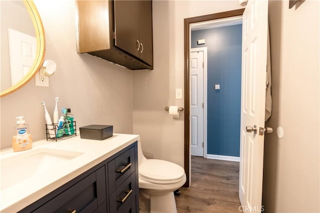 bathroom with hardwood / wood-style floors, vanity, and toilet