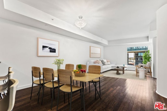 dining room featuring dark hardwood / wood-style floors and a tray ceiling