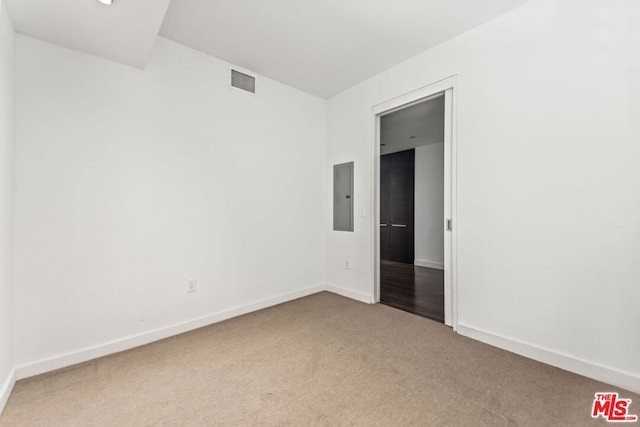 empty room with light colored carpet and electric panel