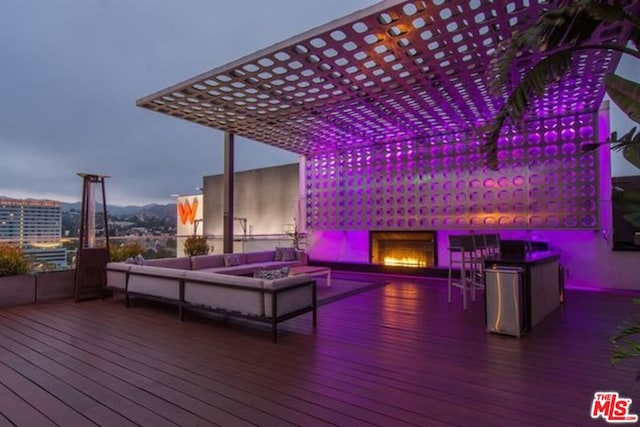 wooden terrace featuring an outdoor living space with a fire pit