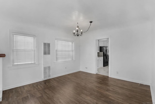 interior space featuring a notable chandelier, dark hardwood / wood-style floors, and a wealth of natural light