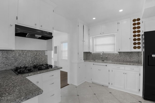 kitchen with white cabinets, backsplash, black appliances, and sink