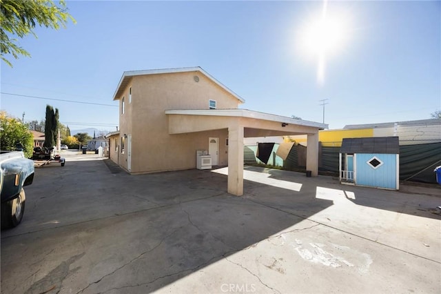 rear view of property with a storage unit