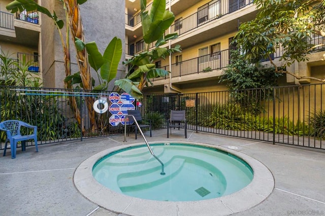 view of pool with a hot tub