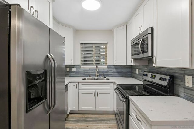 kitchen with sink, white cabinetry, and stainless steel appliances