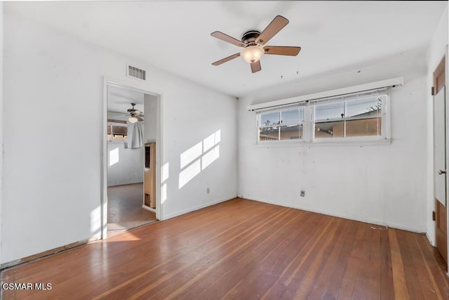 empty room with hardwood / wood-style flooring, plenty of natural light, and ceiling fan