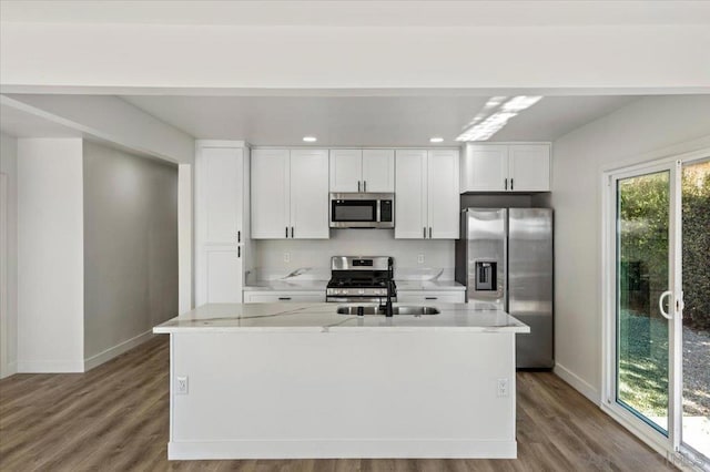 kitchen with white cabinetry, a kitchen island with sink, appliances with stainless steel finishes, and light hardwood / wood-style flooring