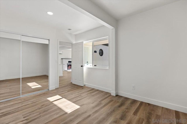 unfurnished bedroom with a closet and wood-type flooring