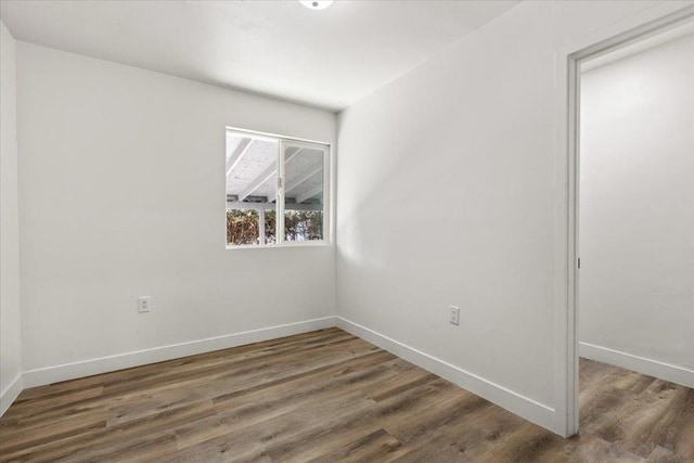 empty room with dark hardwood / wood-style flooring