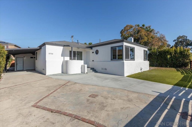 view of front of property featuring a front lawn and a carport