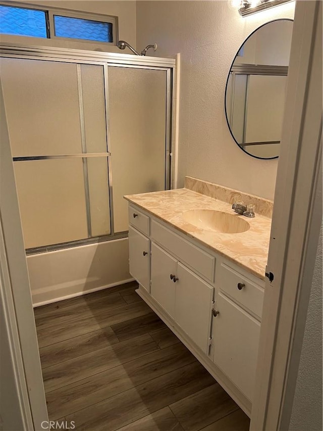 bathroom featuring vanity, combined bath / shower with glass door, and wood-type flooring