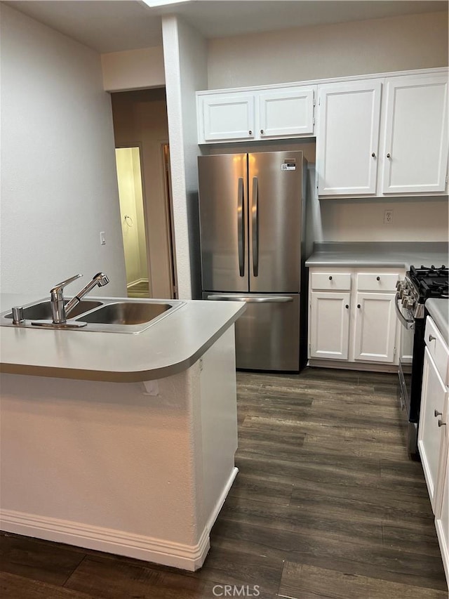 kitchen with stainless steel appliances, dark hardwood / wood-style floors, sink, and white cabinets