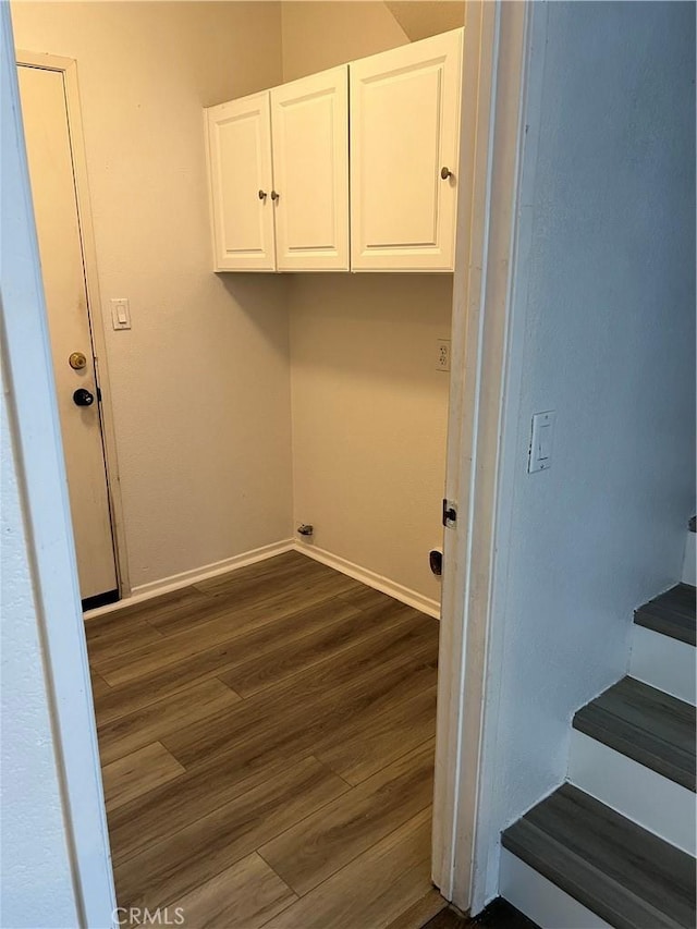 laundry room with dark wood-type flooring and cabinets