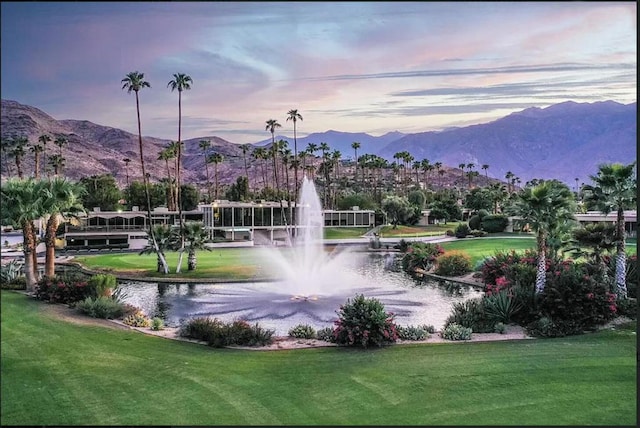 view of property's community featuring a yard and a water and mountain view