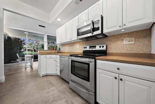 kitchen with white cabinets, backsplash, stainless steel appliances, and sink