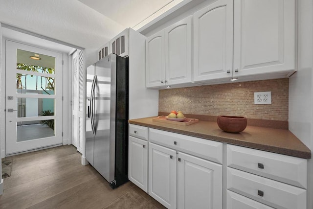 kitchen with white cabinetry, backsplash, and stainless steel fridge with ice dispenser