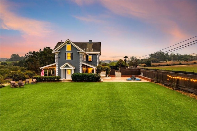 view of front of home featuring a yard and a patio area