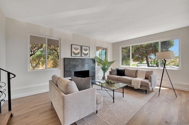 living room with a wealth of natural light, a fireplace, and light wood-type flooring