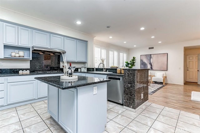 kitchen with dishwasher, a center island, sink, dark stone counters, and light tile patterned floors