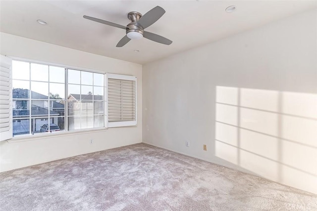 unfurnished room featuring ceiling fan and light colored carpet