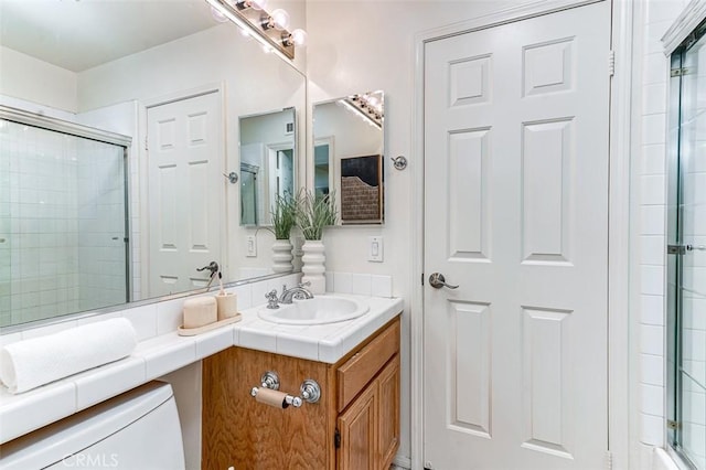 bathroom with vanity, toilet, and walk in shower