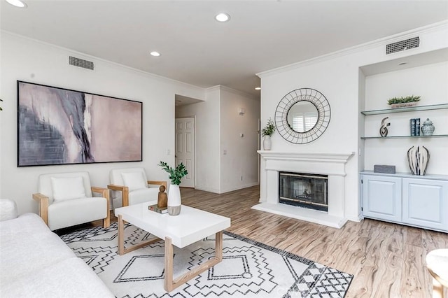 living room with light wood-type flooring and ornamental molding