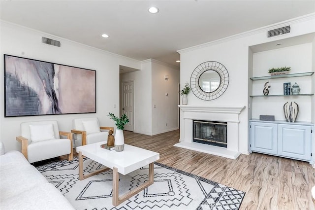 living room featuring light hardwood / wood-style floors and ornamental molding