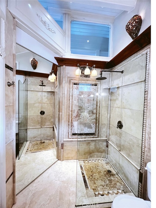 bathroom featuring toilet, beam ceiling, and a tile shower