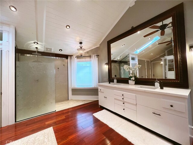 bathroom with vaulted ceiling, wood-type flooring, vanity, ceiling fan, and walk in shower