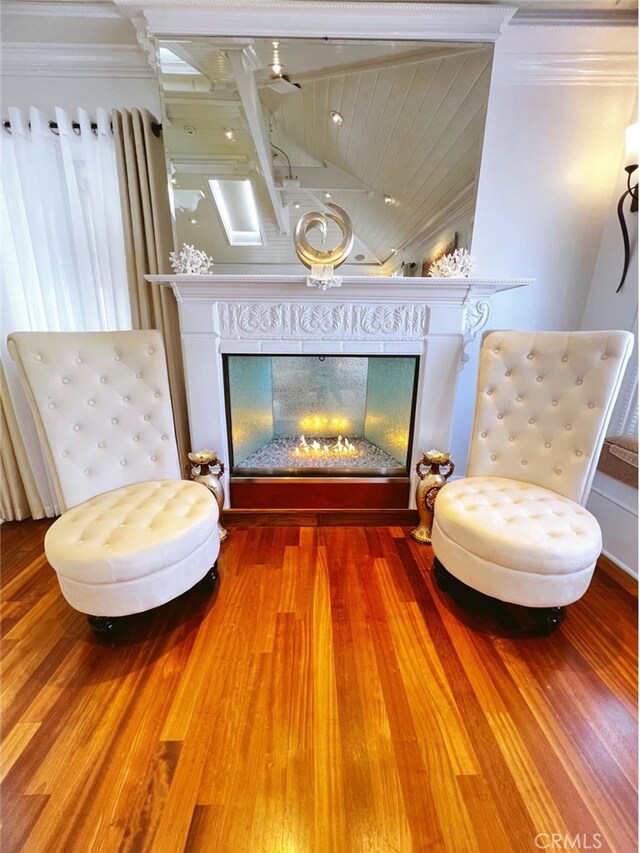 sitting room featuring crown molding, a fireplace, and hardwood / wood-style flooring