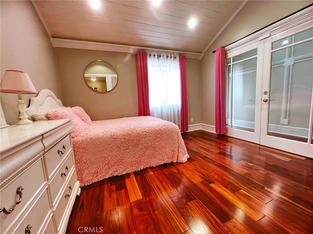 bedroom with hardwood / wood-style flooring, vaulted ceiling, ornamental molding, and french doors