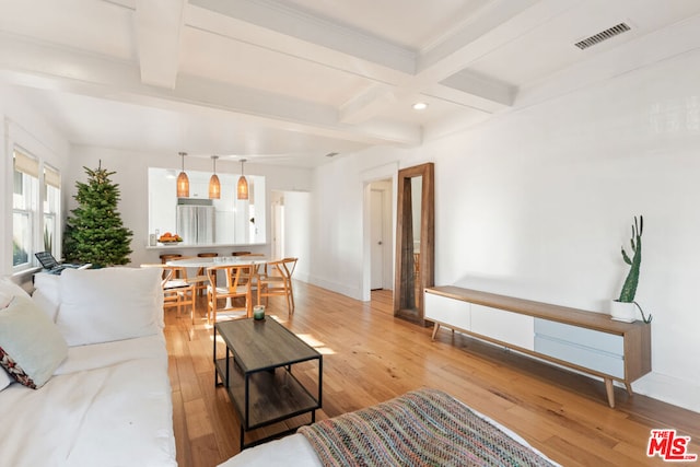 living room featuring beamed ceiling and light wood-type flooring