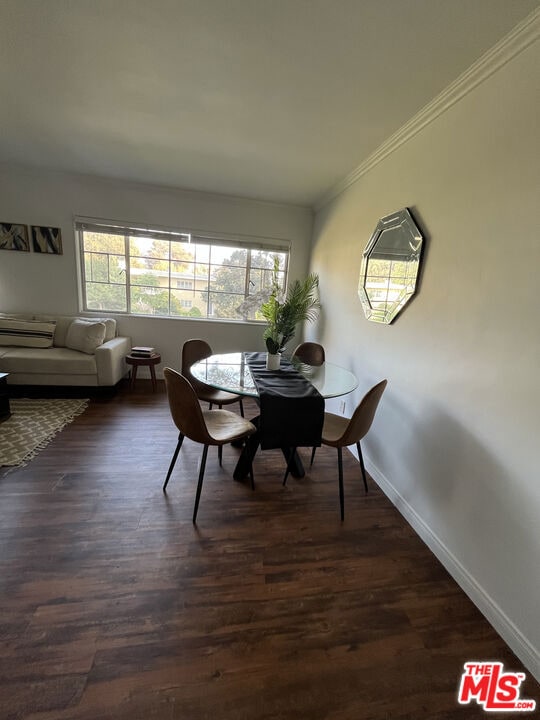 dining room with dark hardwood / wood-style floors and ornamental molding