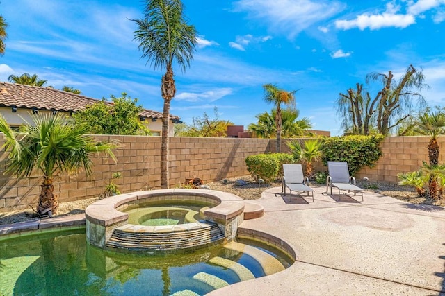 view of swimming pool featuring a patio area and an in ground hot tub