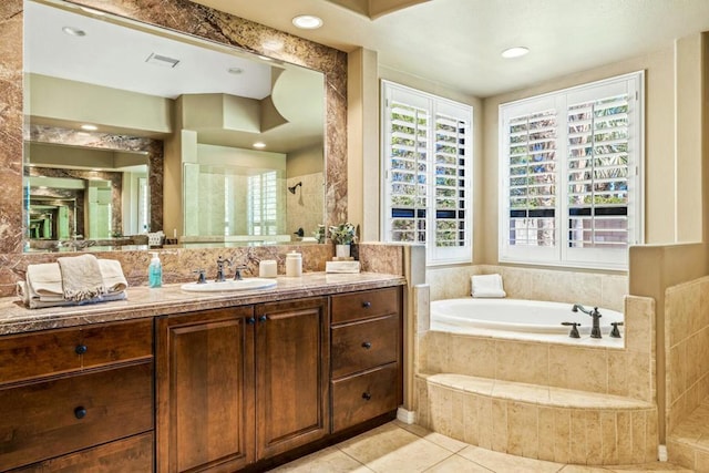 bathroom with tile patterned flooring, vanity, and shower with separate bathtub