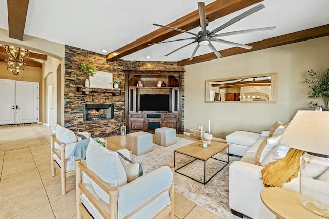 tiled living room with beam ceiling, a stone fireplace, and ceiling fan