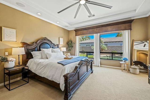 carpeted bedroom featuring a raised ceiling, ceiling fan, and ornamental molding