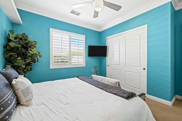 bedroom featuring ceiling fan, a closet, carpet floors, and crown molding