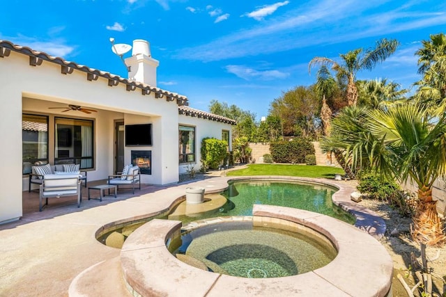 view of swimming pool featuring ceiling fan, a patio area, and an in ground hot tub