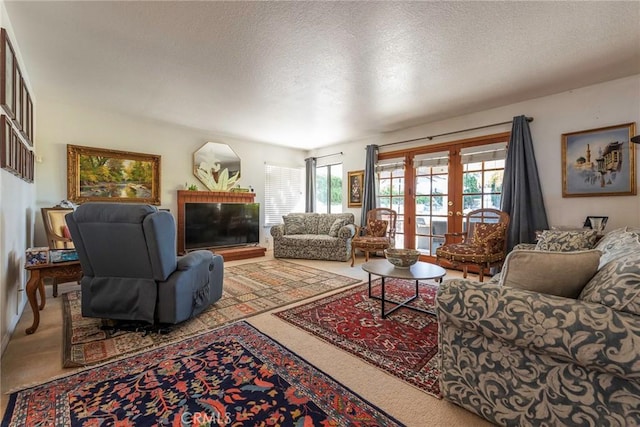 living room featuring carpet floors, a glass covered fireplace, a textured ceiling, and french doors