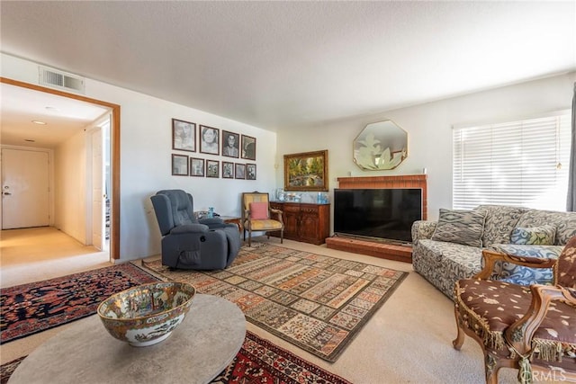 carpeted living area with visible vents and a fireplace