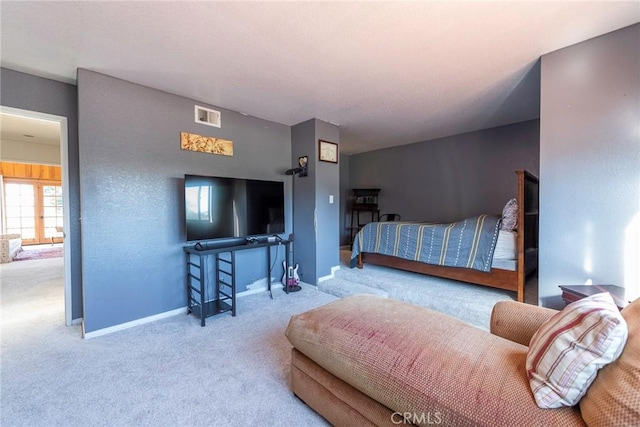 bedroom with light carpet, visible vents, and baseboards