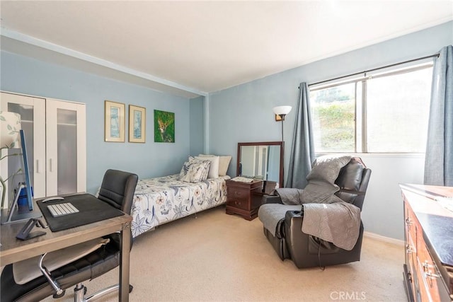 bedroom with baseboards and light colored carpet