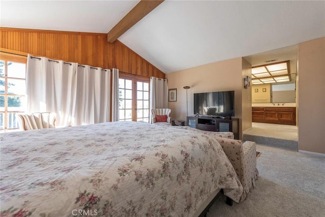 carpeted bedroom featuring lofted ceiling with beams, sink, ensuite bathroom, and multiple windows