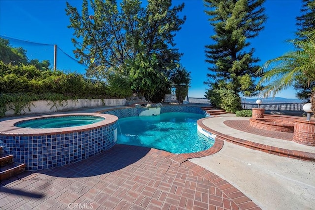 view of swimming pool with a patio area and a pool with connected hot tub