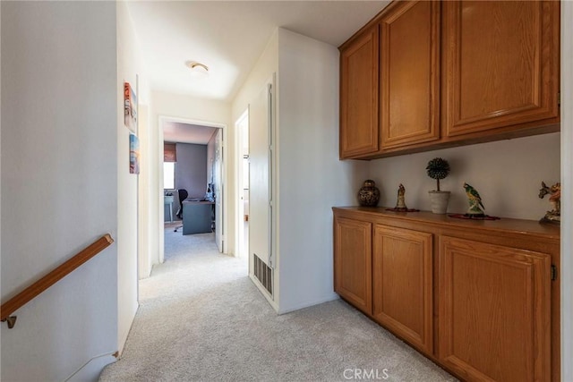 hall with light carpet and visible vents